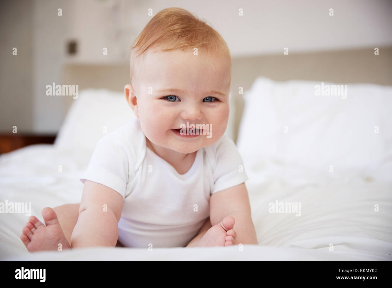 Happy Baby Boy Sitting On Parents Bed Stock Photo