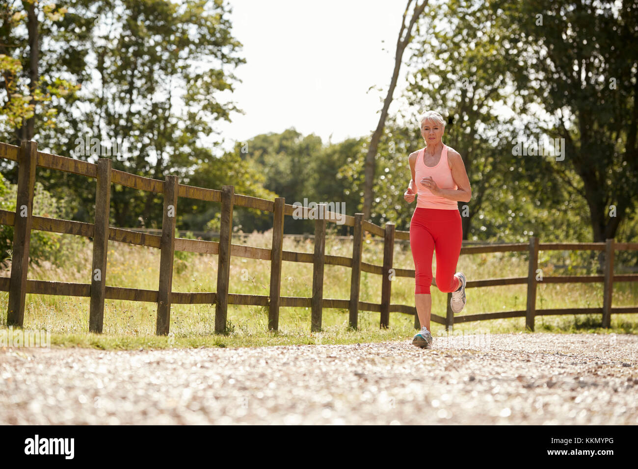 Healthy Senior Woman Enjoying Run Through Countryside Stock Photo