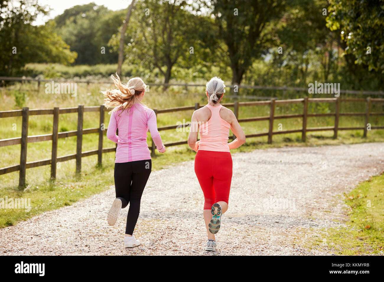 Young And Senior Women Enjoying Run Through Countryside Together Stock Photo