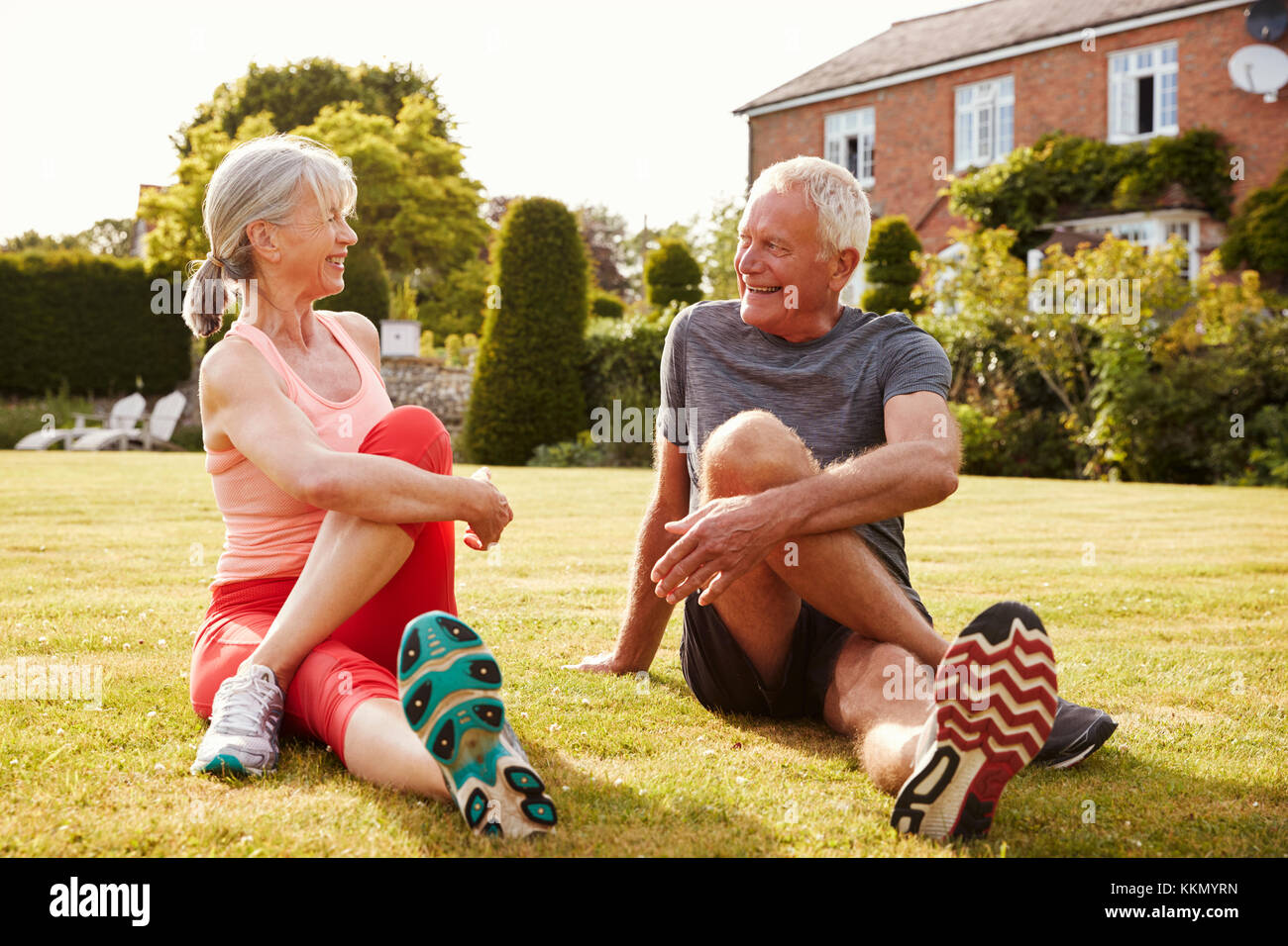 Healthy Senior Couple Exercising In Garden Together Stock Photo