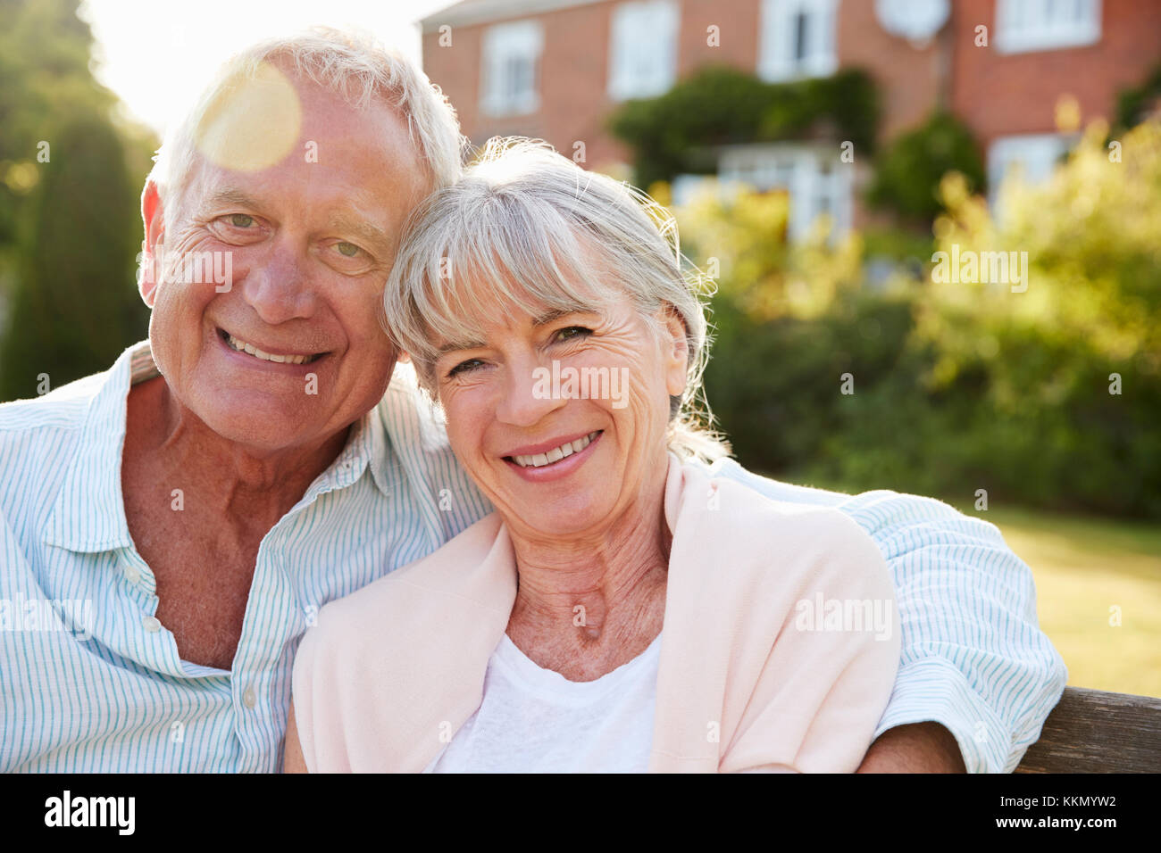 Senior Couple Sitting On Garden Bench In Evening Sunlight Stock Photo ...