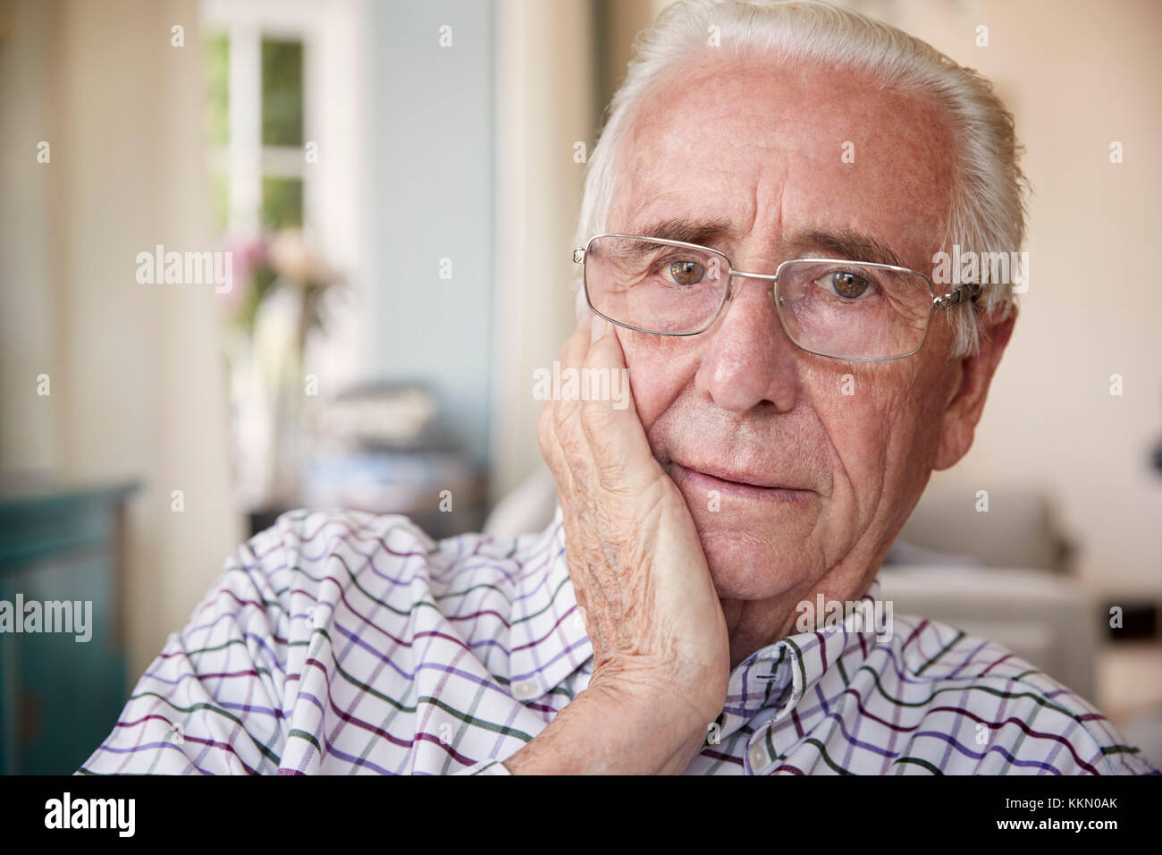 Worried senior man at home looking to camera, close up Stock Photo