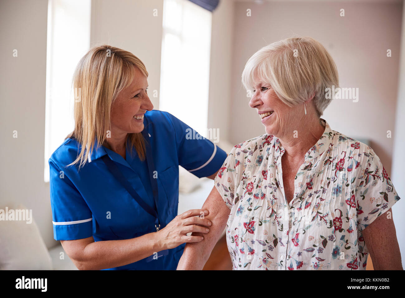 nurse-helping-senior-woman-use-a-walking-frame-close-up-stock-photo