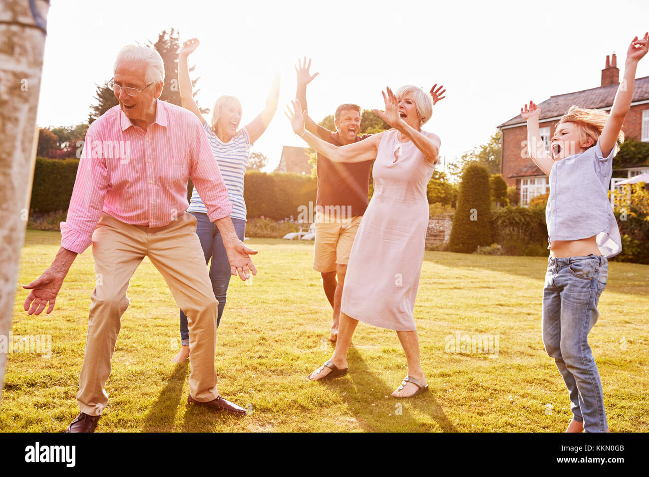 Multi generation family playing football in the garden Stock Photo - Alamy