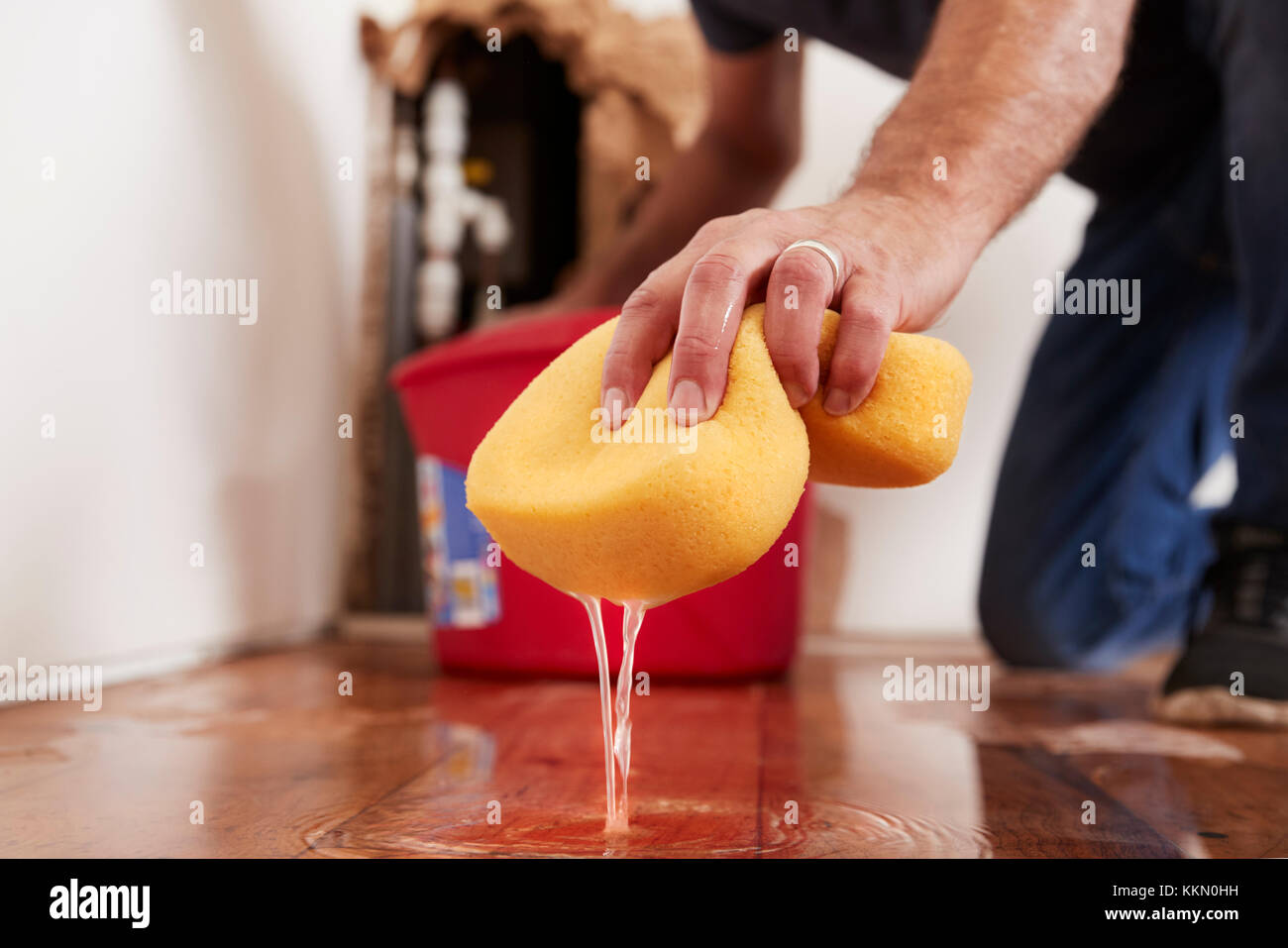 Man mopping up water from the floor with a sponge, detail Stock Photo