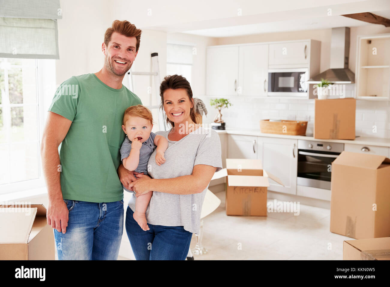 Portrait Of Family With Baby On Moving In Day Stock Photo