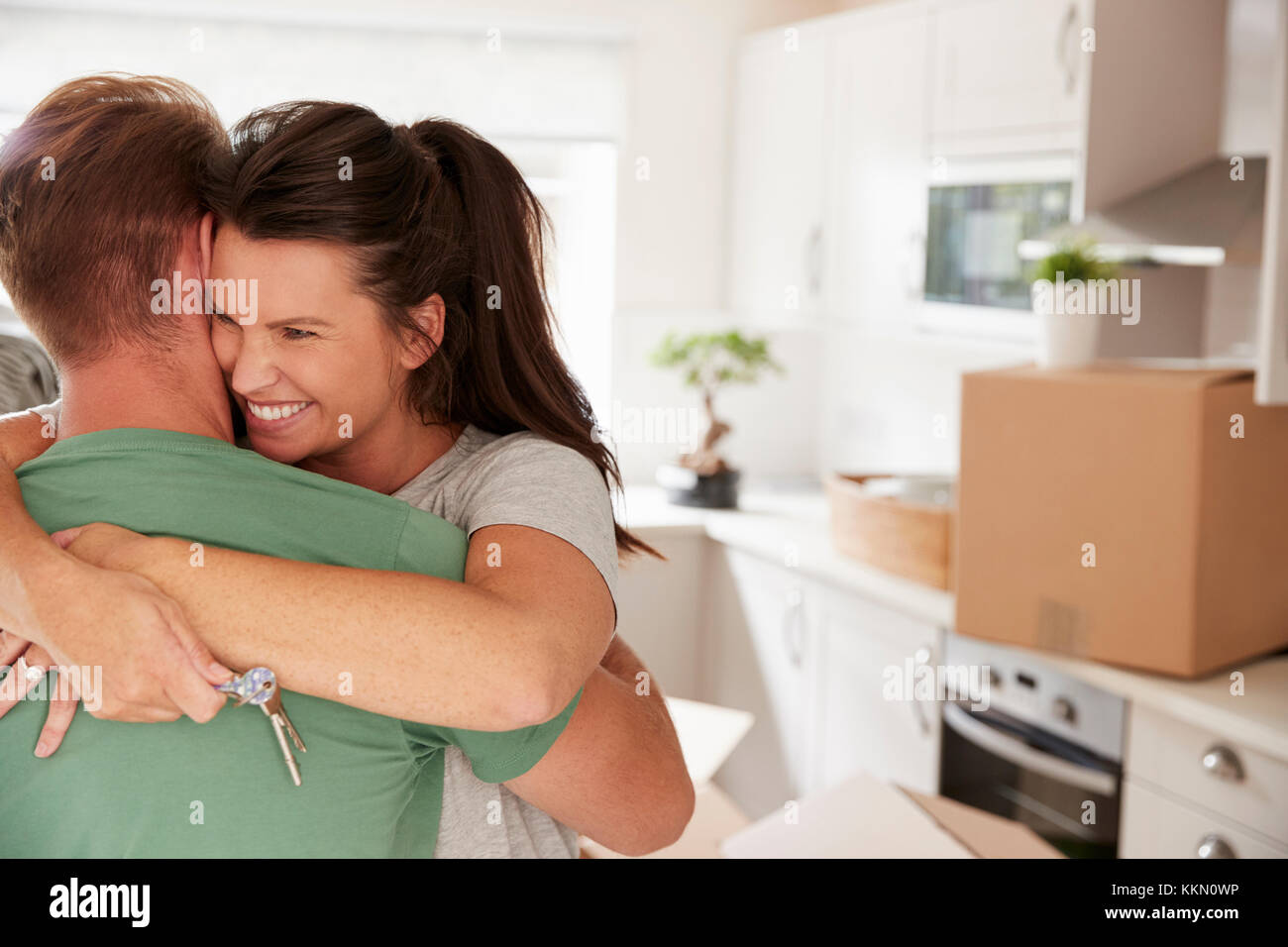 Hugging Couple Celebrating Moving Into New Home Stock Photo