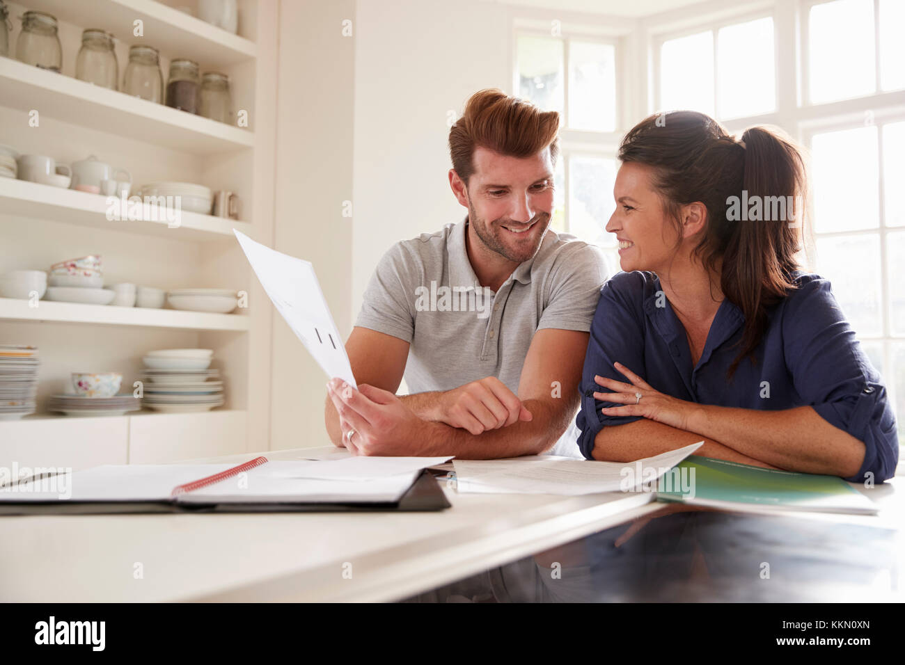 Couple Looking At Domestic Finances At Home Together Stock Photo