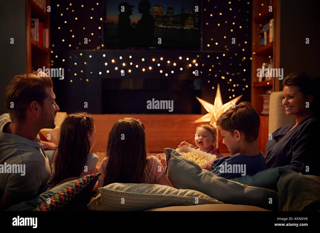 Family Enjoying Movie Night At Home Together Stock Photo