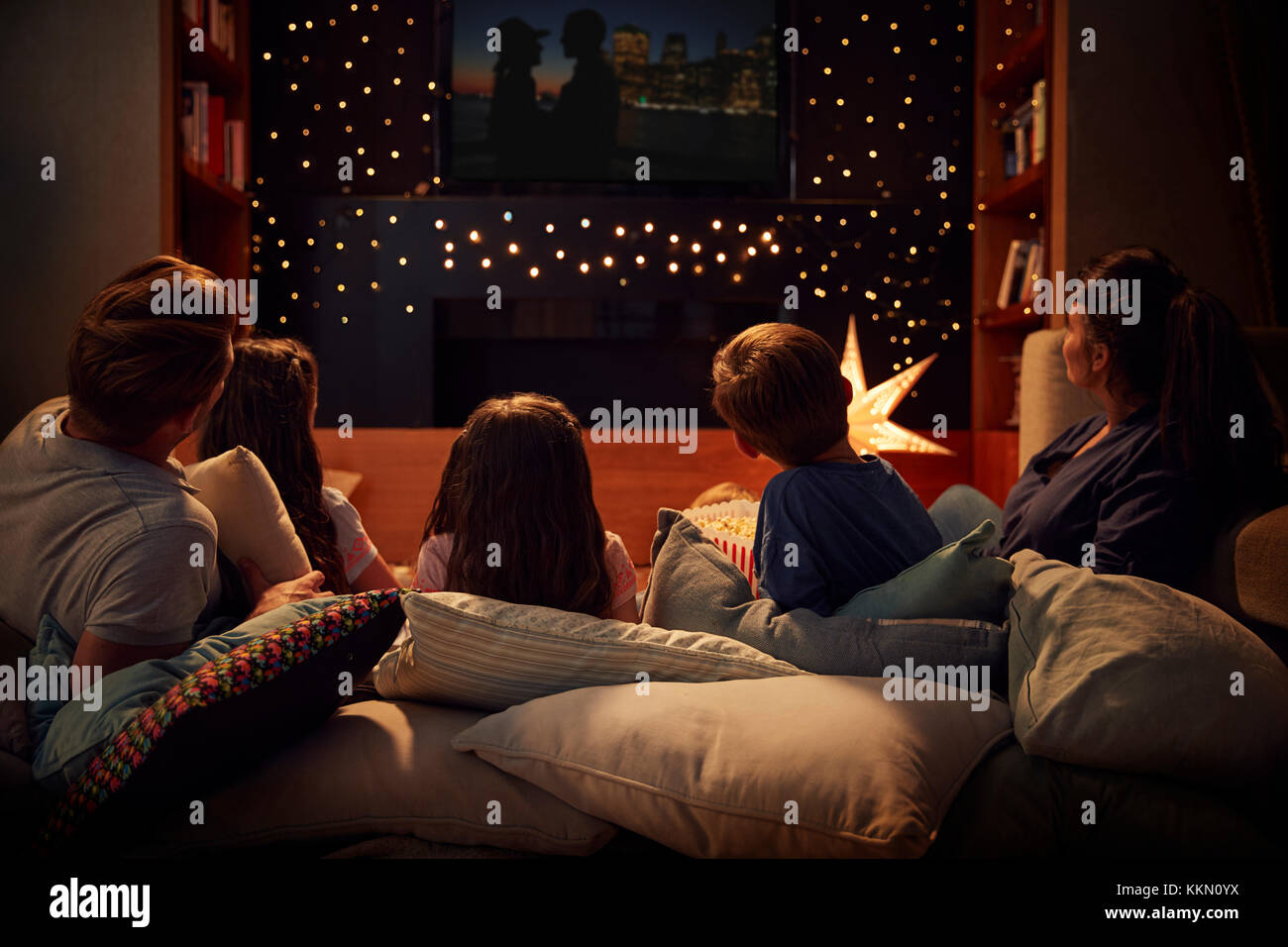 Family Enjoying Movie Night At Home Together Stock Photo