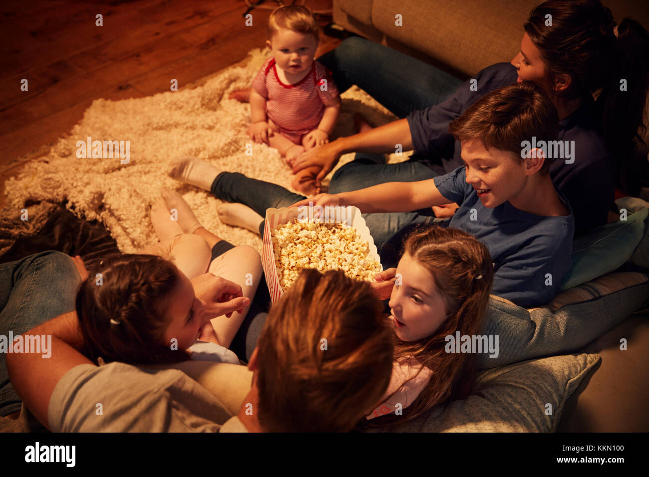 Overhead View Of Family Enjoying Movie Night At Home Together Stock Photo