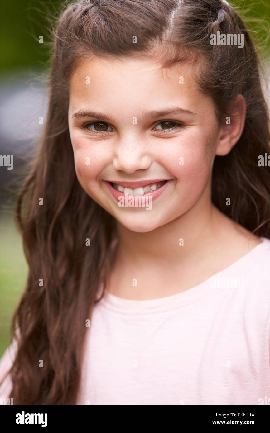 Portrait Of Smiling Young Girl Standing Outdoors In Garden Stock Photo