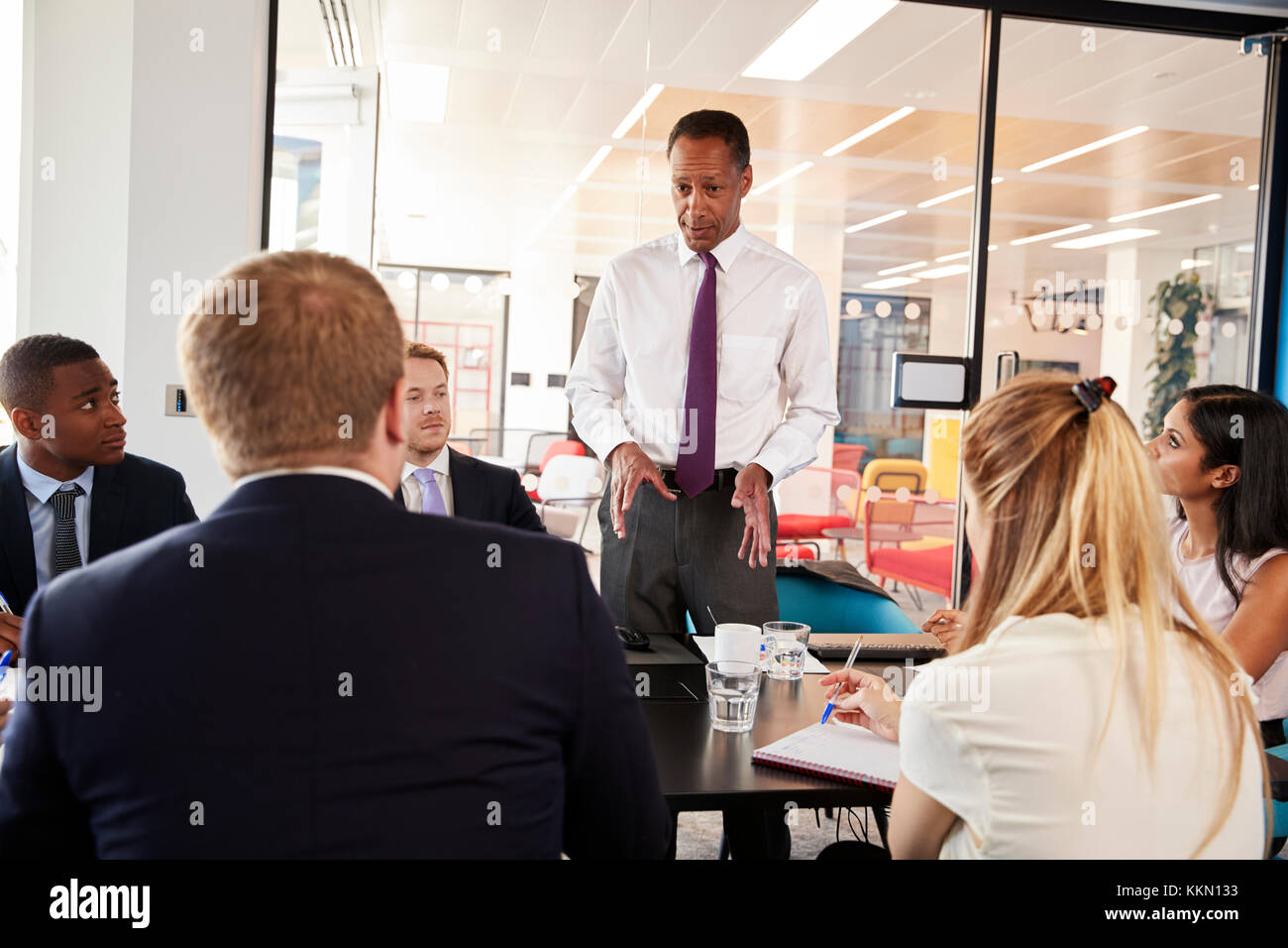 Black male manager stands talking at a business meeting Stock Photo - Alamy