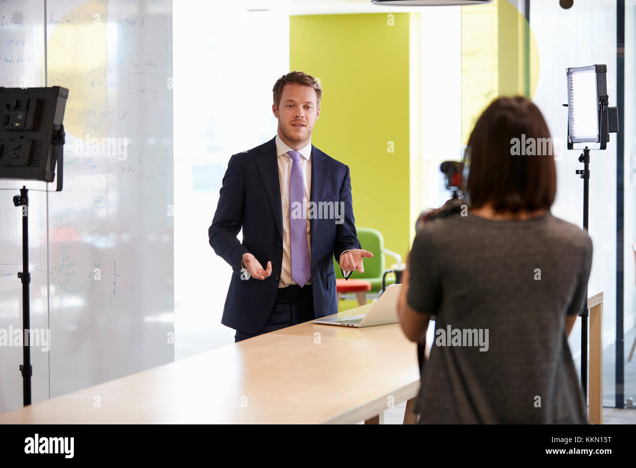 Woman filming a man for a corporate demonstration video Stock Photo