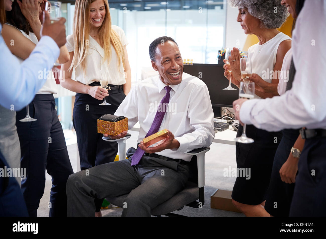 Coworkers celebrating a colleague’s retirement in the office Stock Photo