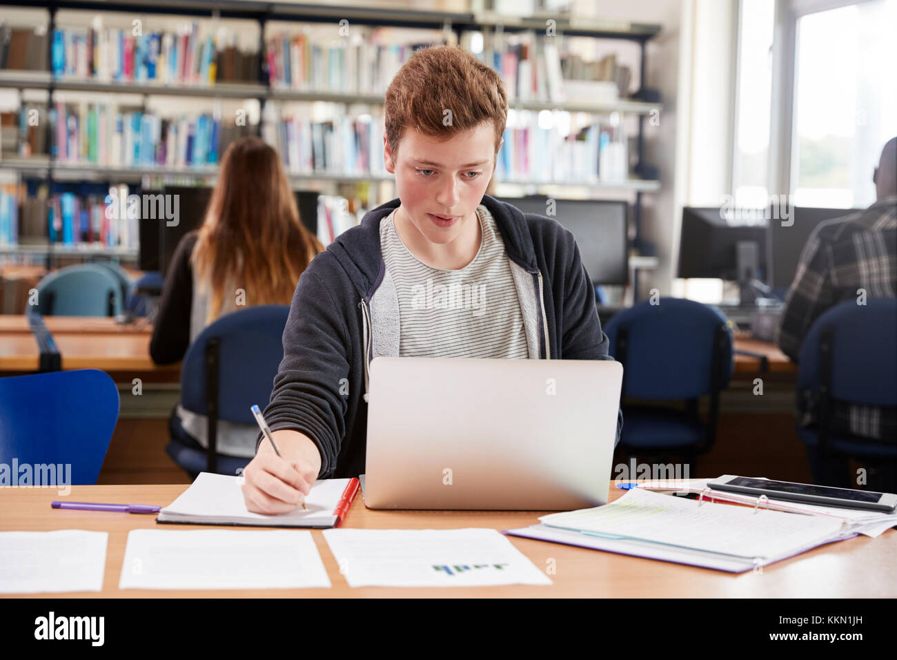 Male Student Working At Laptop In College Library Stock Photo