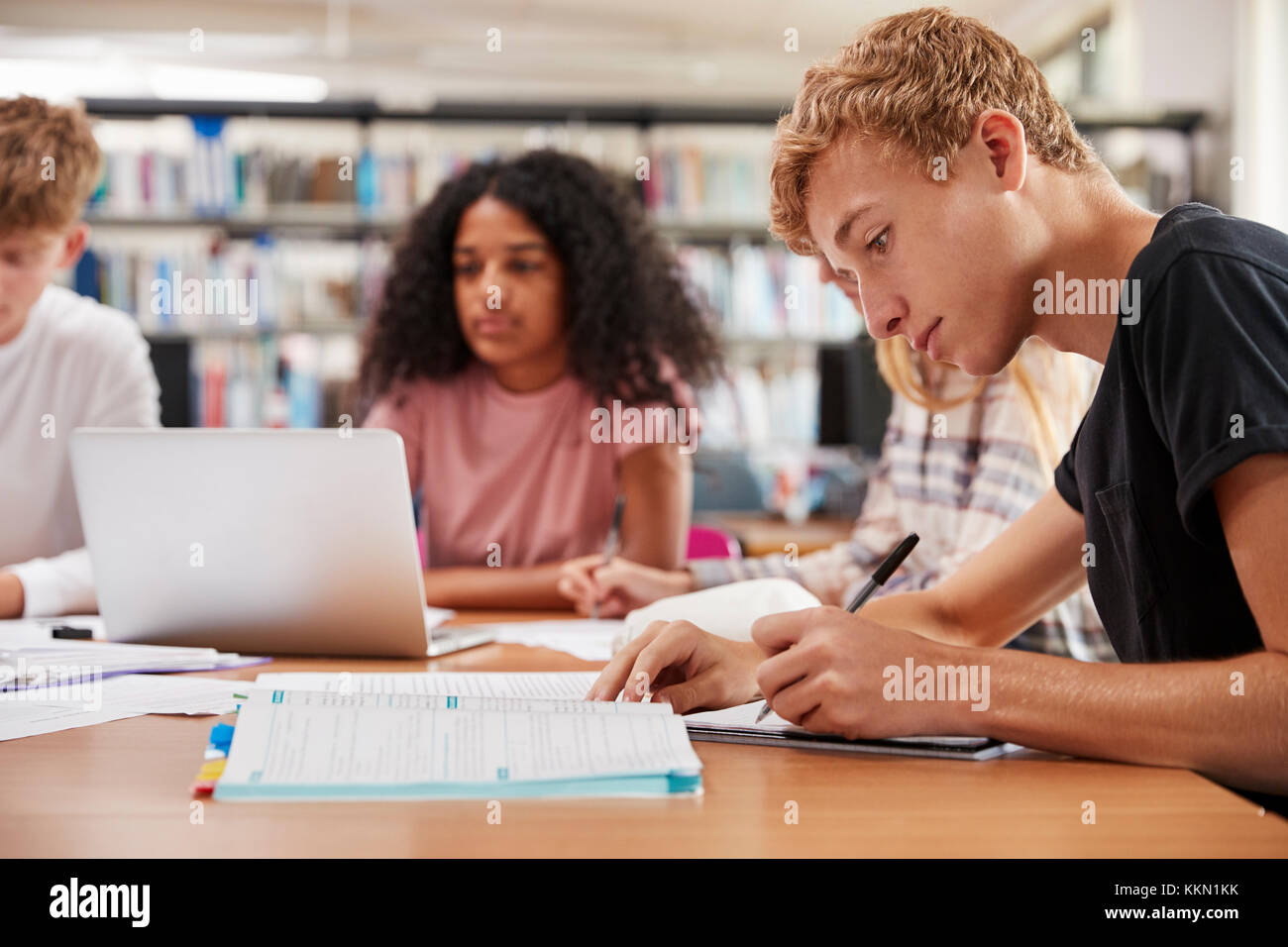 Group Of College Students Working Around Table In Library Stock Photo