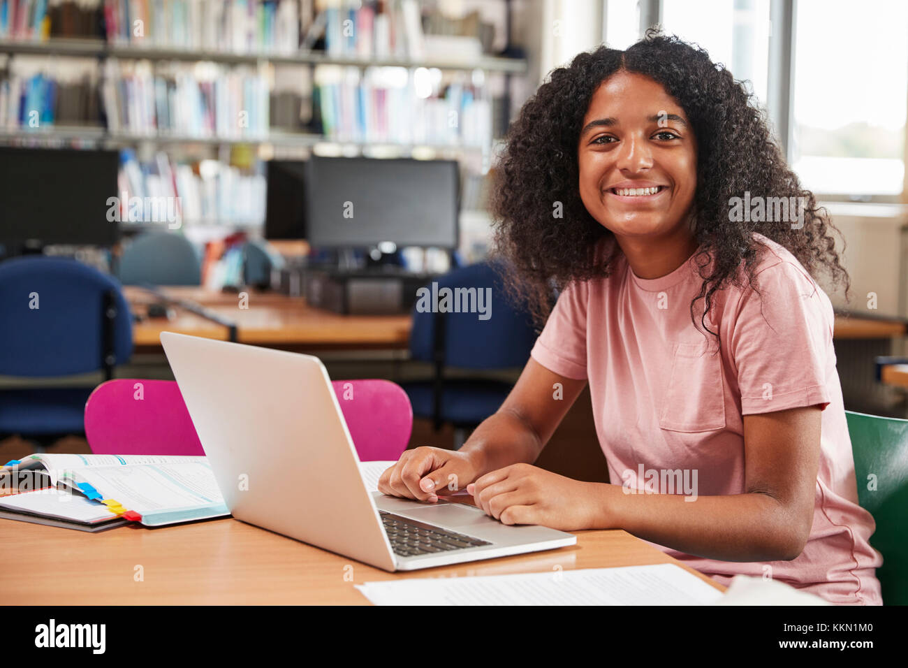 Portrait Of Female Student Working At Laptop In College Library Stock Photo
