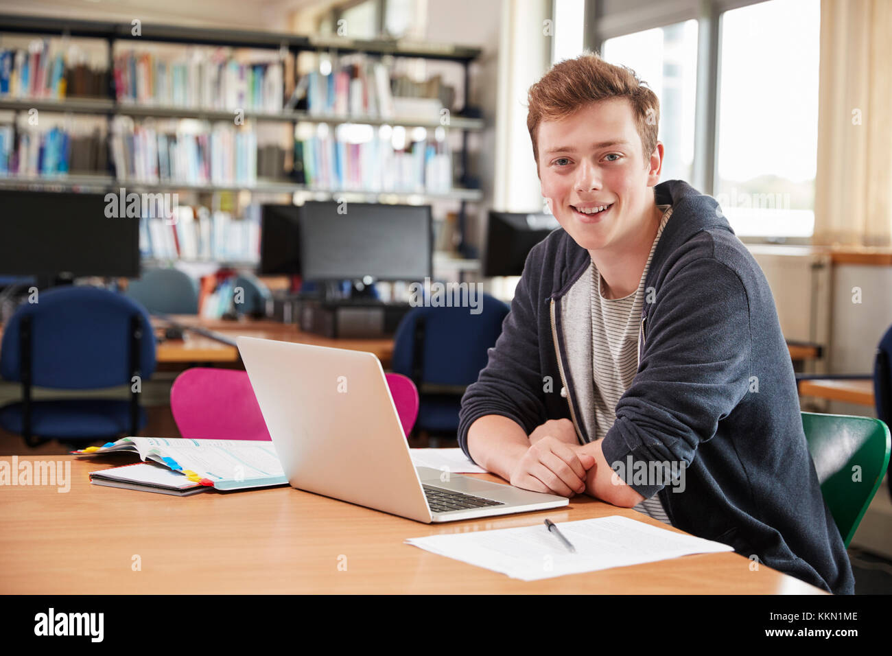 Portrait Of Male Student Working At Laptop In College Library Stock Photo