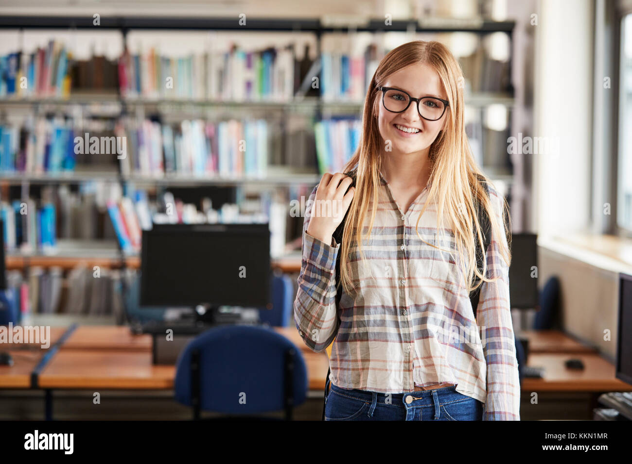 Portrait Of Female Student Standing In College Library Stock Photo