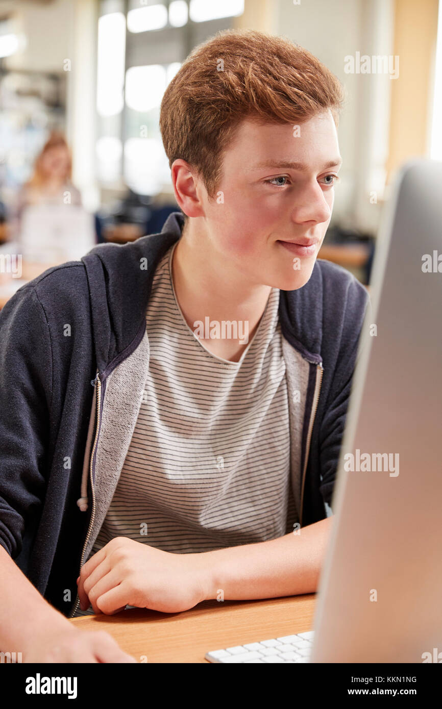 Male Student Working On Computer In College Library Stock Photo