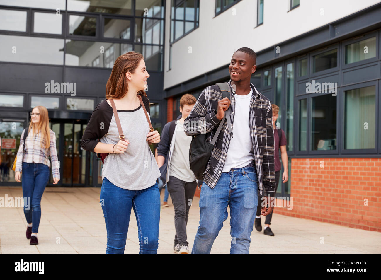 Group Of Students Walking Outside College Buildings Stock Photo