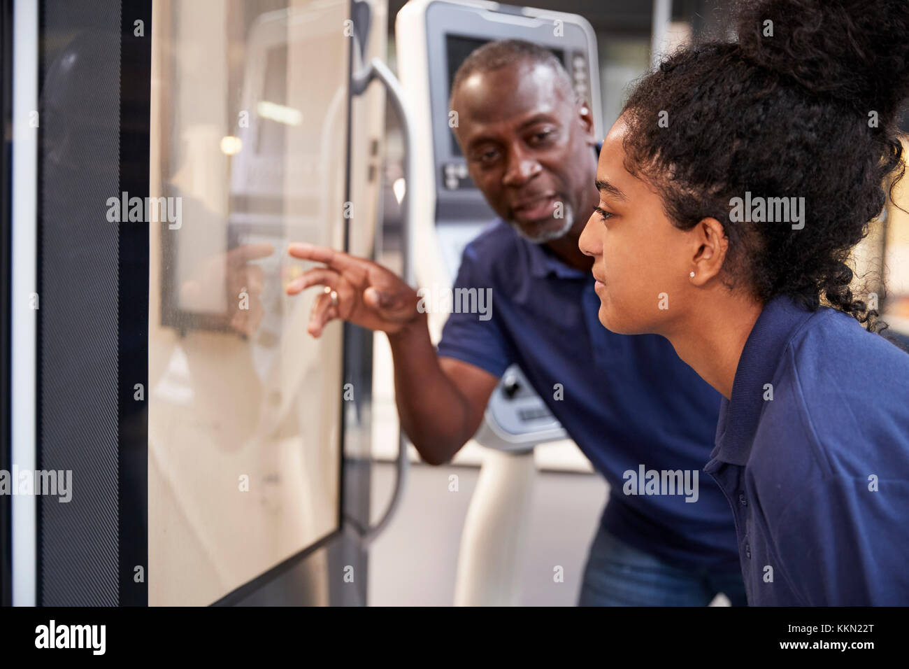 Engineer Showing Apprentice How To Use CNC Tool Making Machine Stock Photo