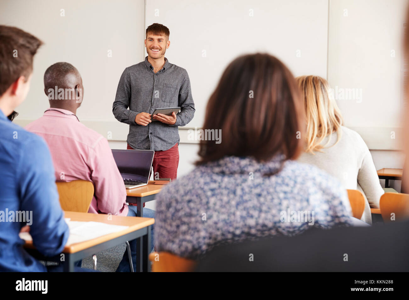 College Tutor With Digital Tablet Teaches Mature Students Stock Photo