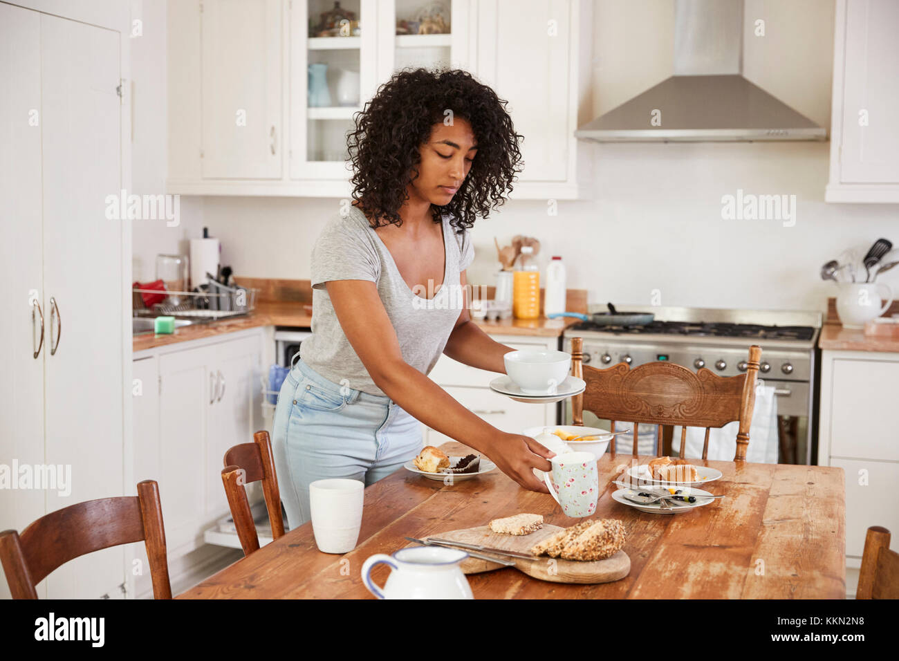 Teenage Girl Clearing Breakfast Table And Loading Dishwasher Stock Photo -  Alamy