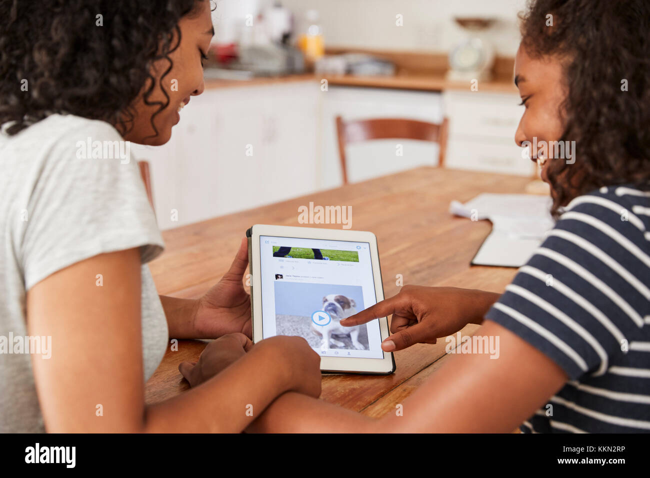 Two Teenage Girls Using Social Media On Digital Tablet Stock Photo