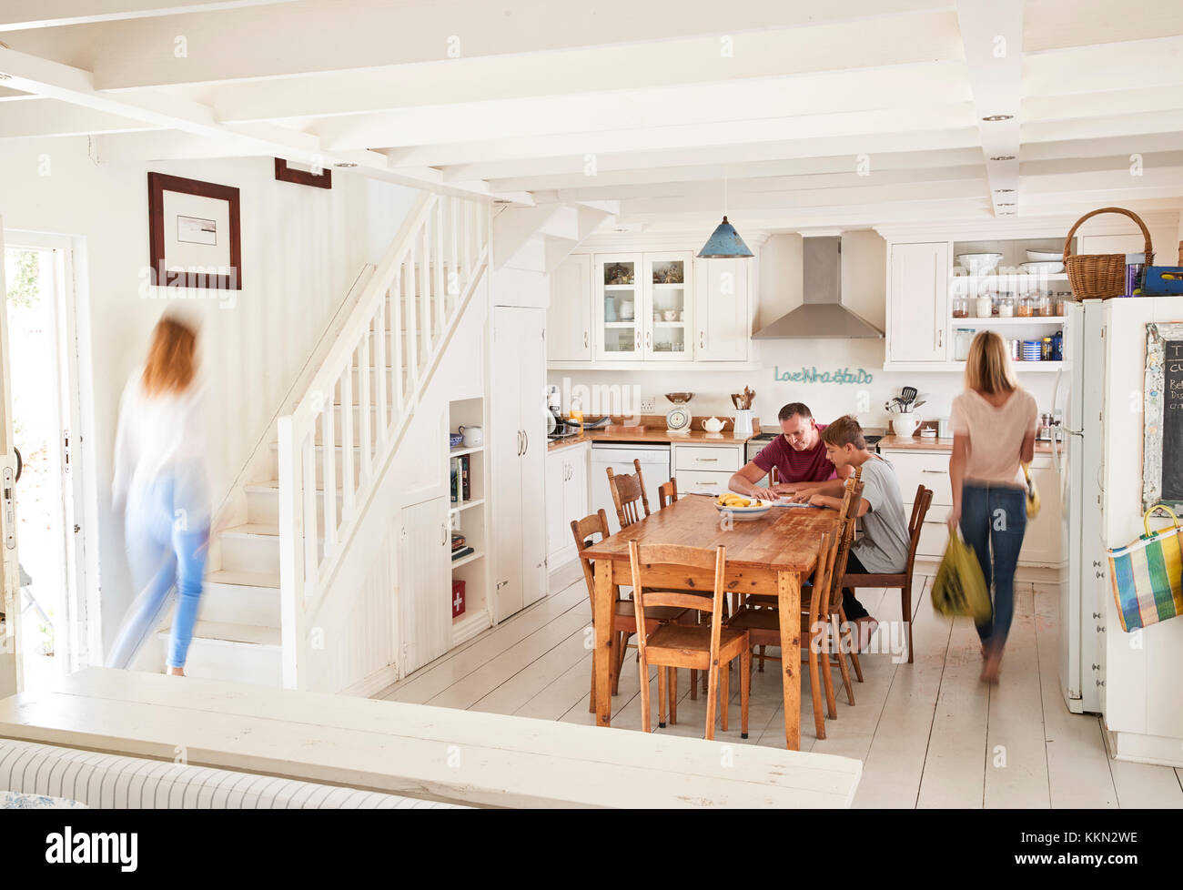 Interior Of Busy Family Home With Blurred Figures Stock Photo