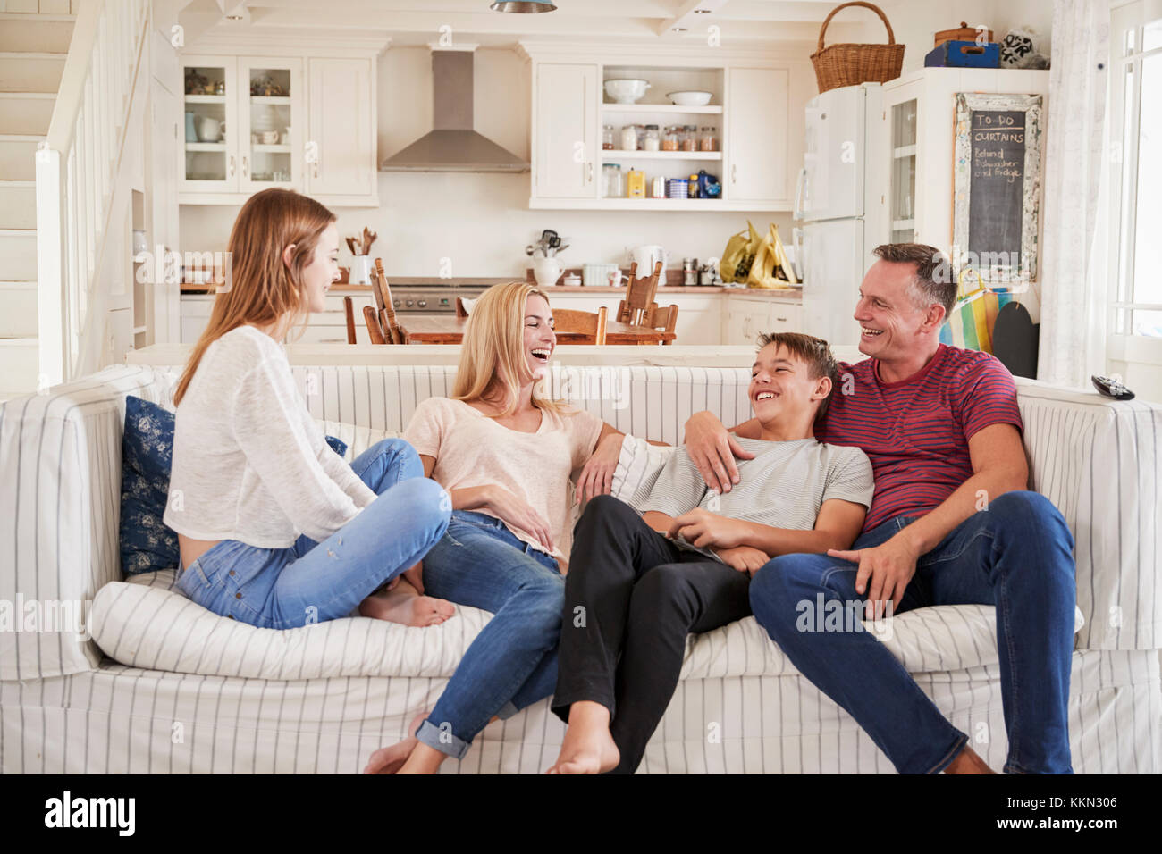 Family With Teenage Children Relaxing On Sofa Together Stock Photo