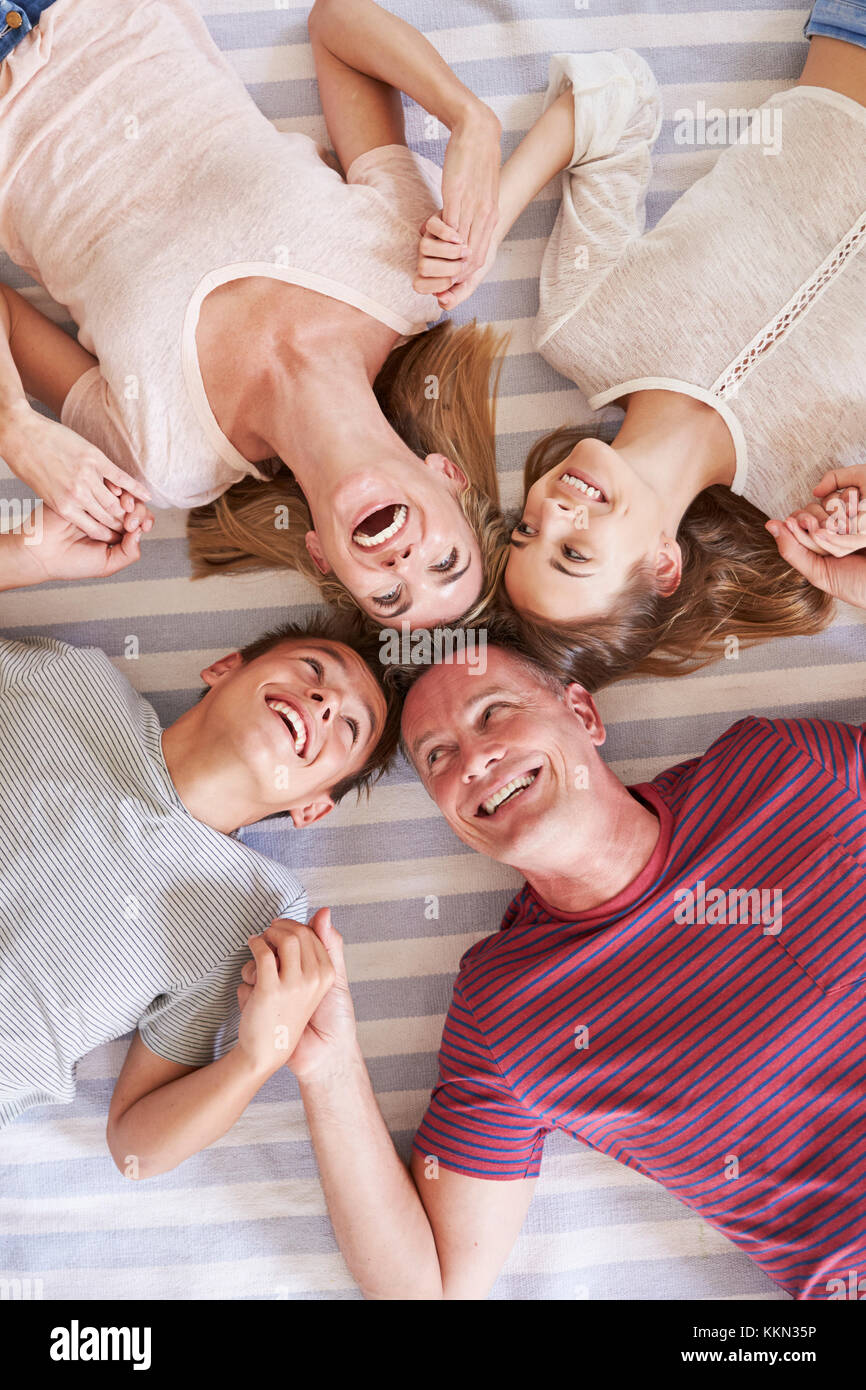 Overhead View Of Family With Teenage Children Lying On Bed Stock Photo