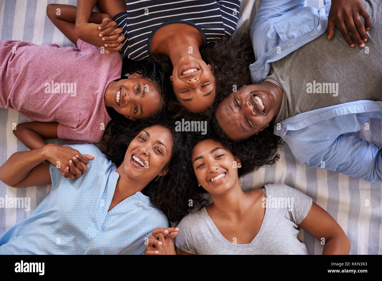 Overhead View Of Family With Teenage Children Lying On Bed Stock Photo