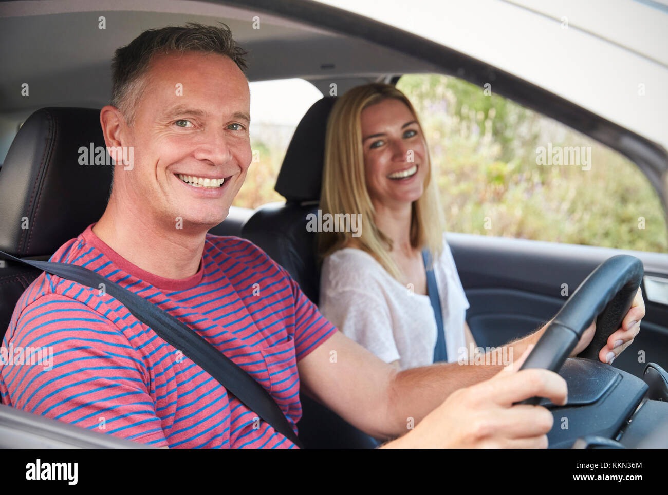 Portrait Of Mature Couple Sitting In Car On Road Trip Stock Photo