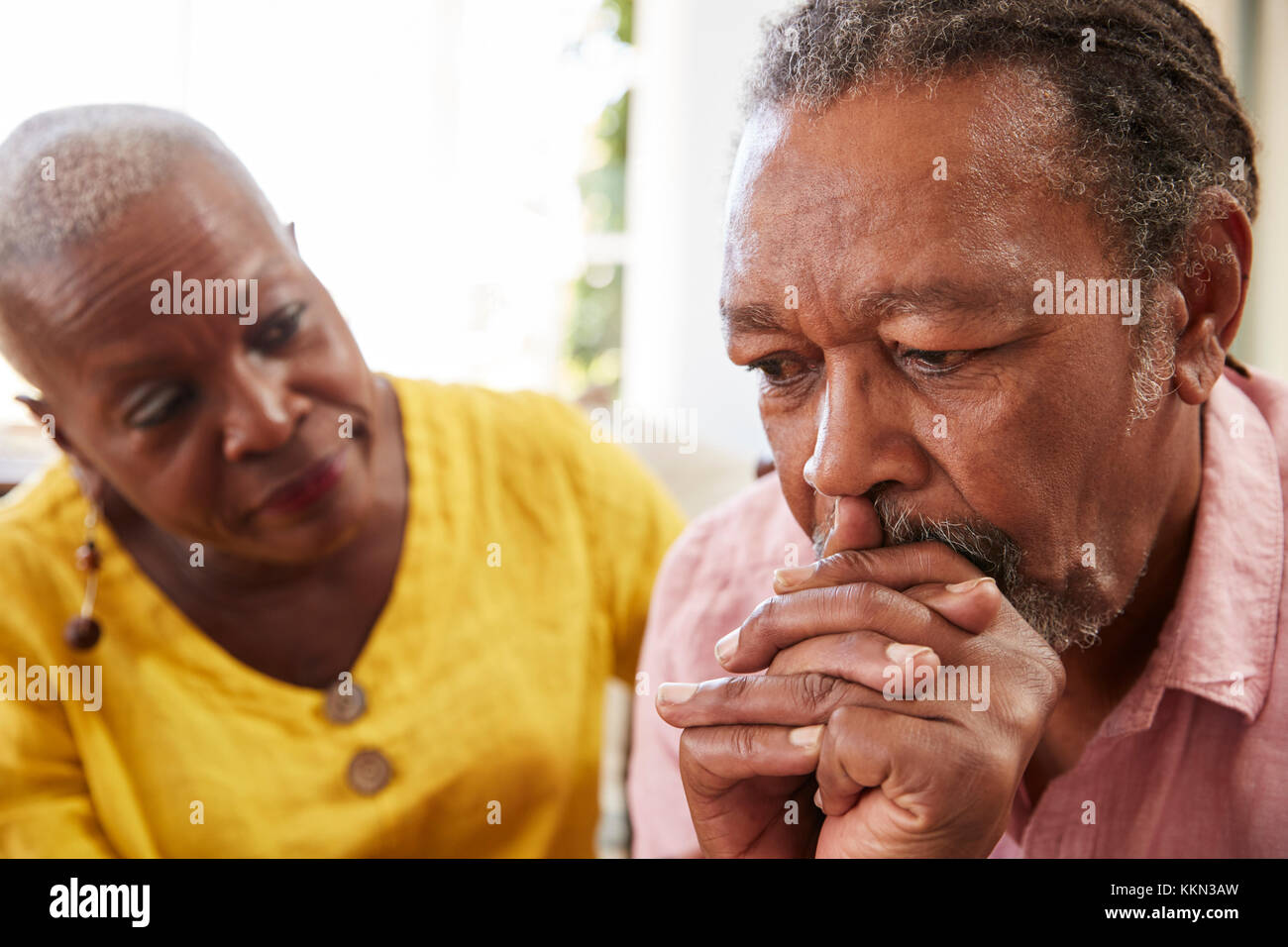Senior Woman Comforting Man With Depression At Home Stock Photo