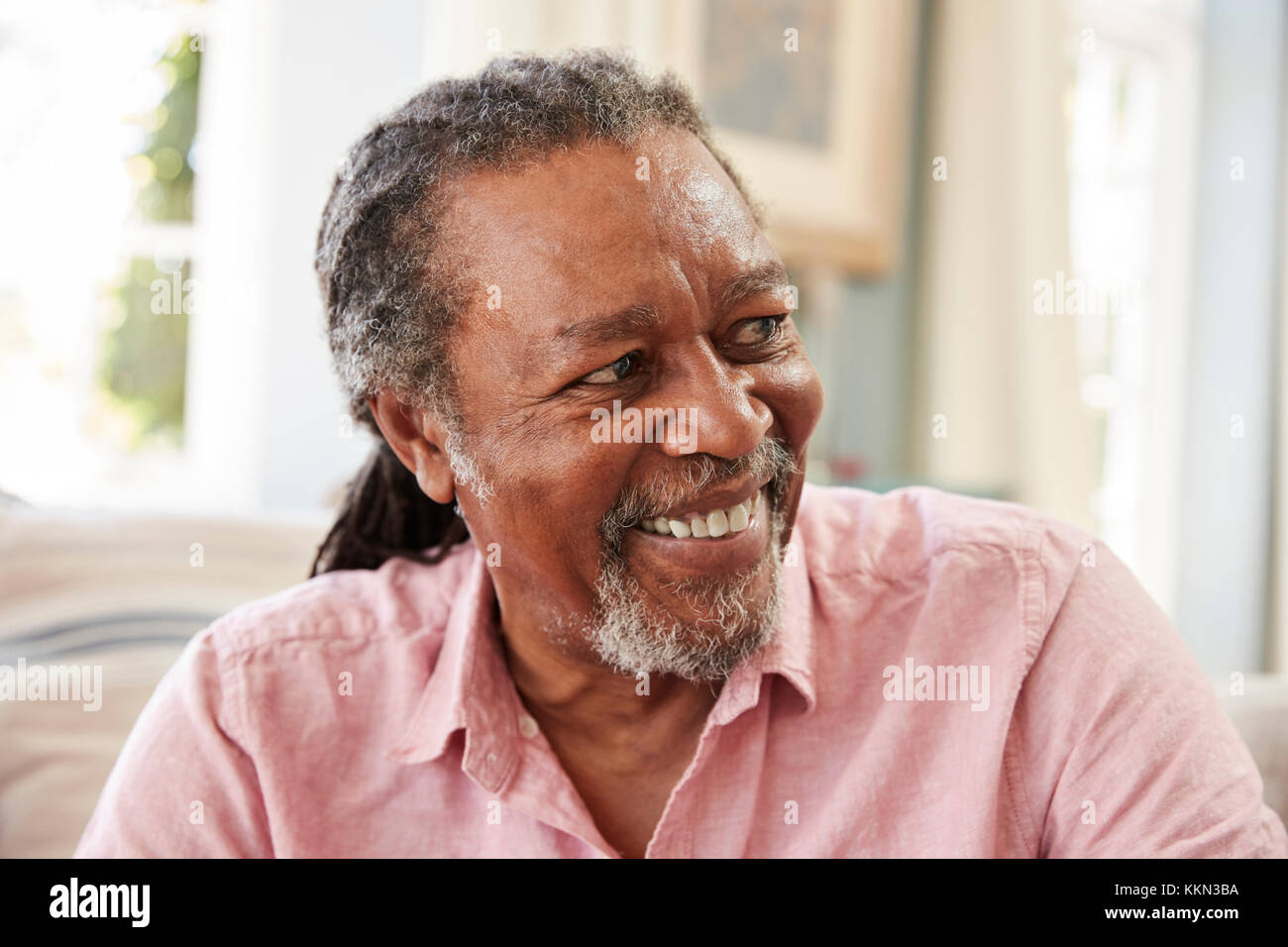 Smiling Senior Man Sitting On Sofa At Home Stock Photo - Alamy