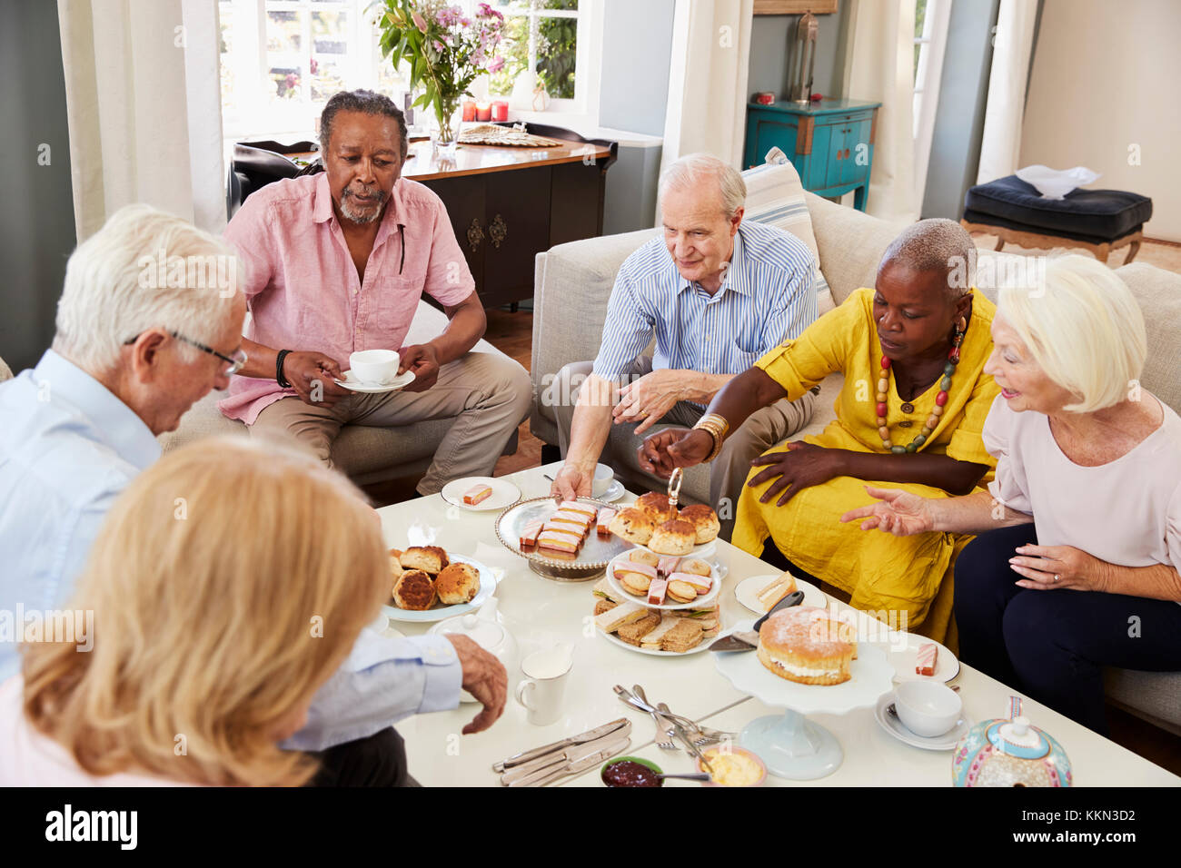 Group Of Senior Friends Enjoying Afternoon Tea At Home Together Stock Photo