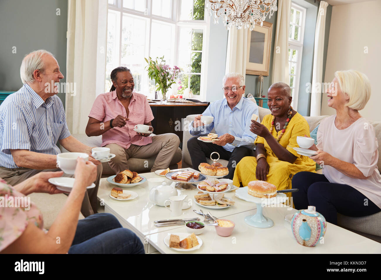 Group Of Senior Friends Enjoying Afternoon Tea At Home Together Stock Photo