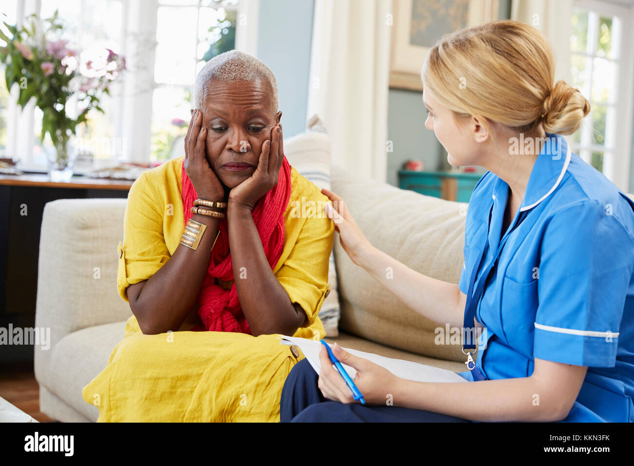 Community Nurse Visits Senior Woman Suffering With Depression Stock Photo
