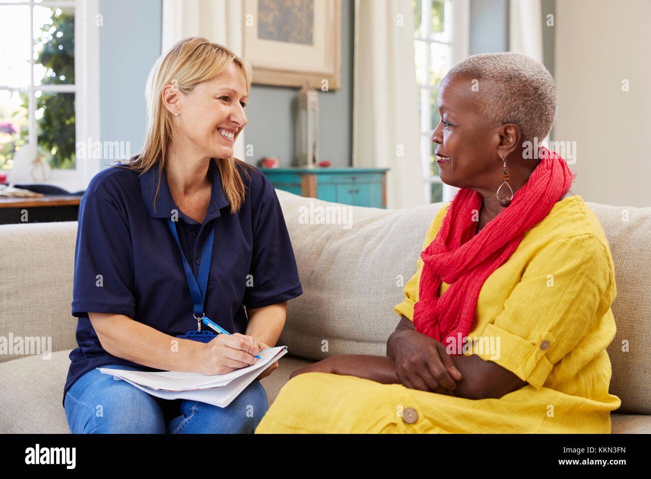 Female Support Worker Visits Senior Woman At Home Stock Photo