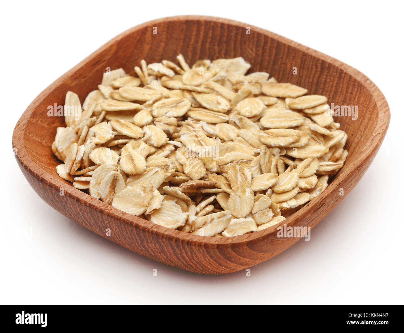 Oats in wooden bowl isolated over white background Stock Photo
