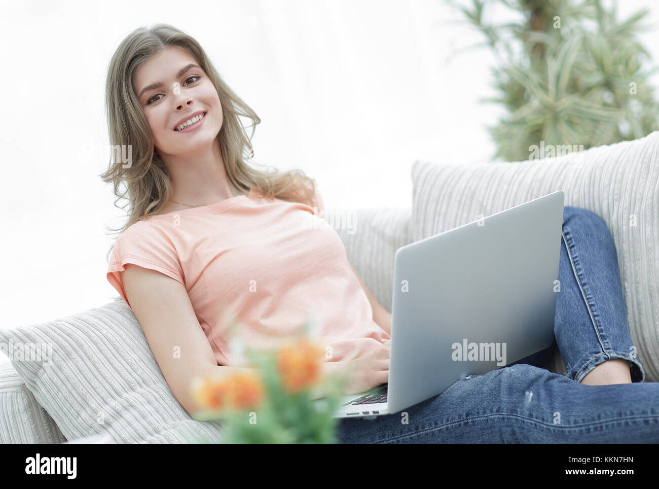 beautiful girl with a laptop sitting on the couch Stock Photo - Alamy