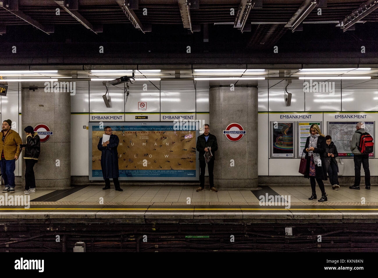 People waiting on the platform at Embankment tube train station on London Underground Stock Photo