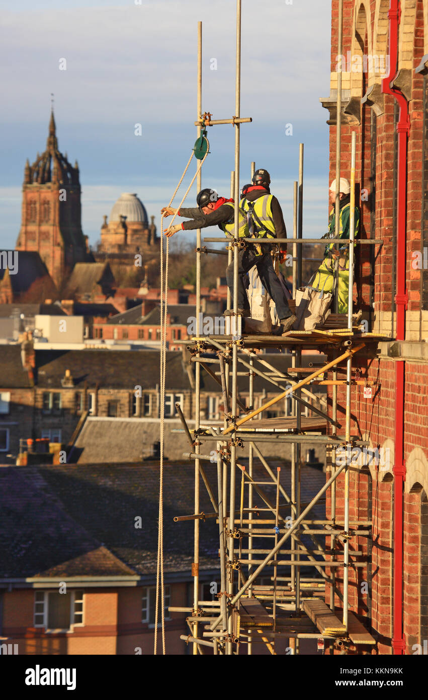 Workmen dismantling scaffolding using a pulley system Stock Photo Alamy