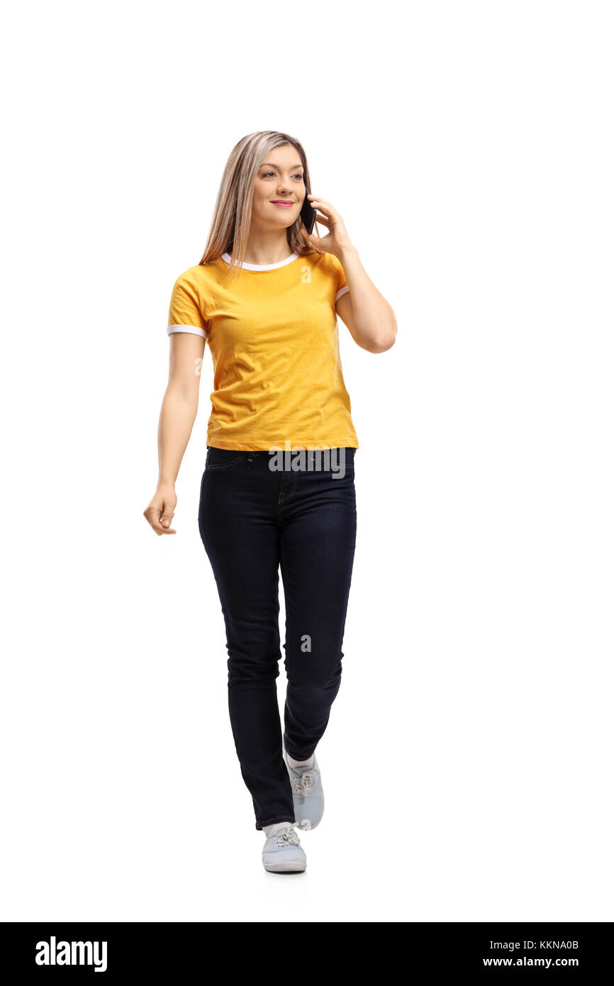 Full length portrait of a woman walking and taking on a phone isolated on white background Stock Photo
