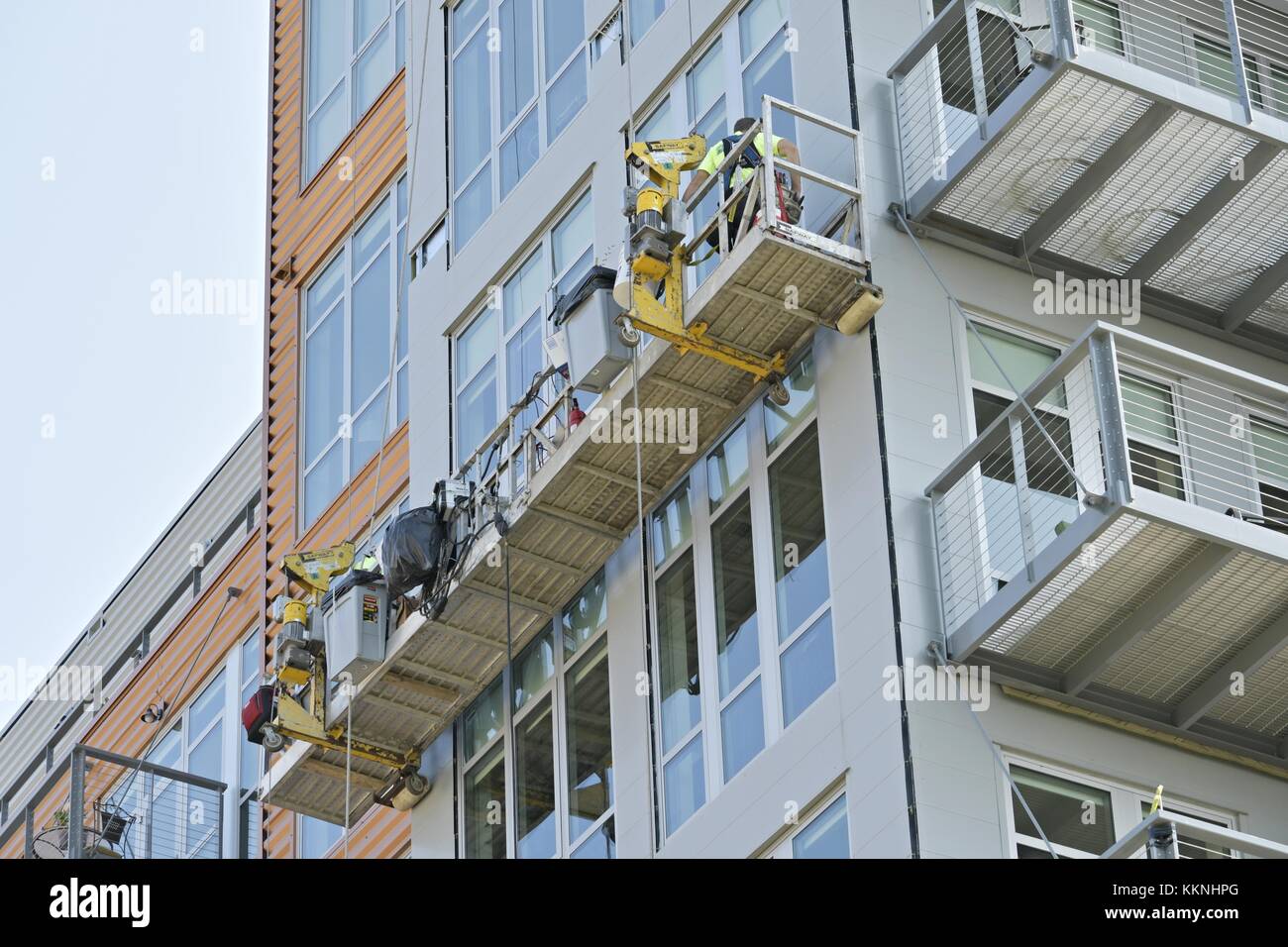 GREEN BAY, WISCONSIN - AUGUST 12, 2017: window cleaners working on ther exterior of a building in a basket in Green Bay, Wisconsin Stock Photo