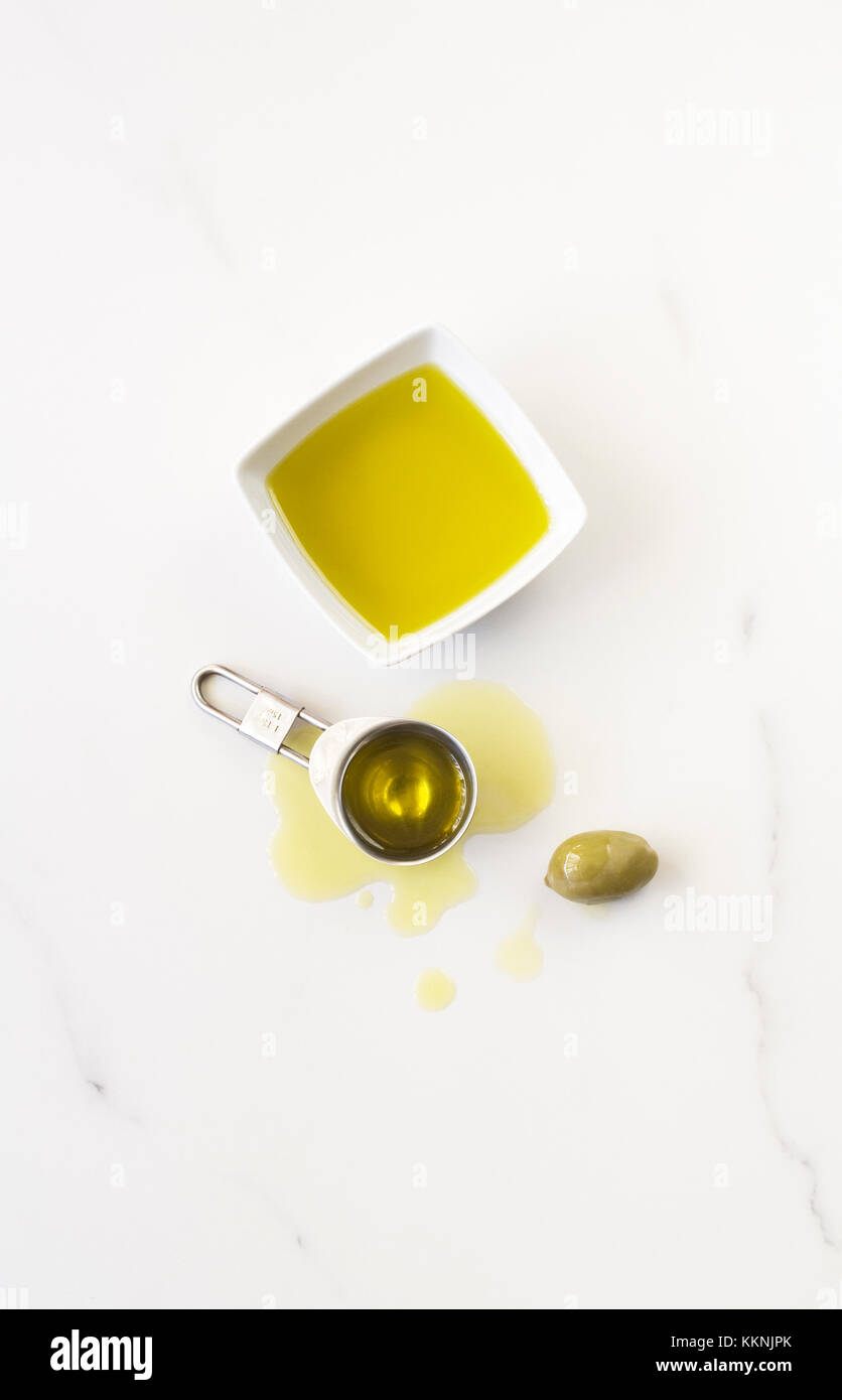 Extra virgin olive oil on a marble background. Stock Photo