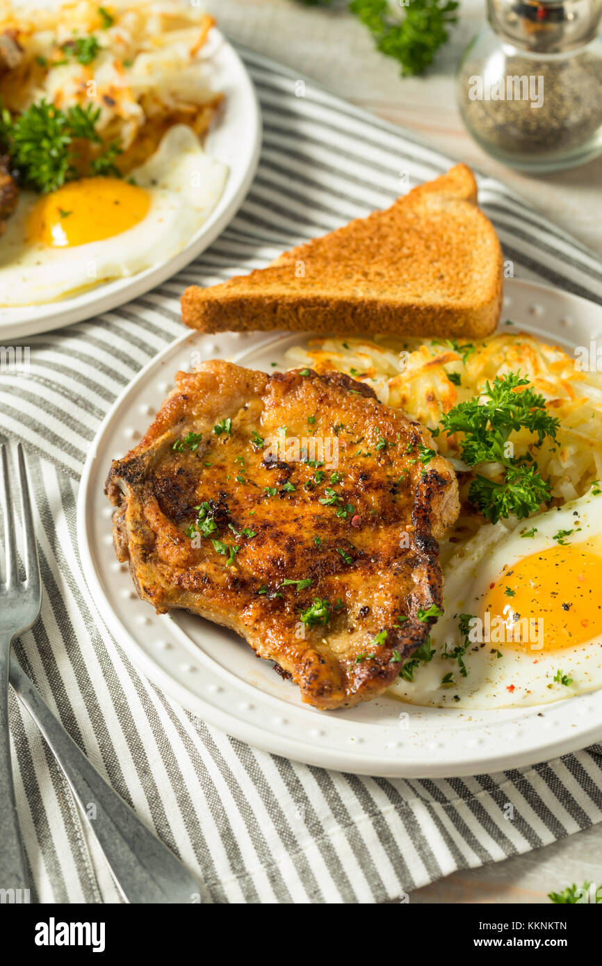 Homemade Fried Breakfast Pork Chops with Eggs and Potatoes Stock Photo