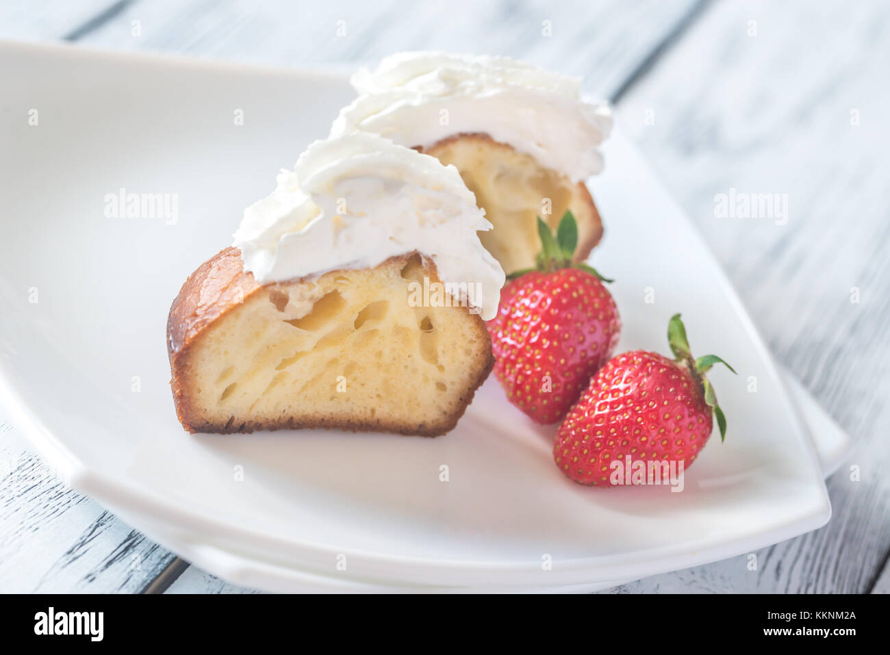 Rum baba decorated with whipped cream on the plate Stock Photo Alamy